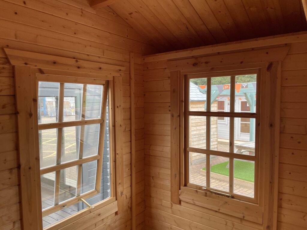 Interior view with two Georgian-style windows—one open with brass stay, one closed.