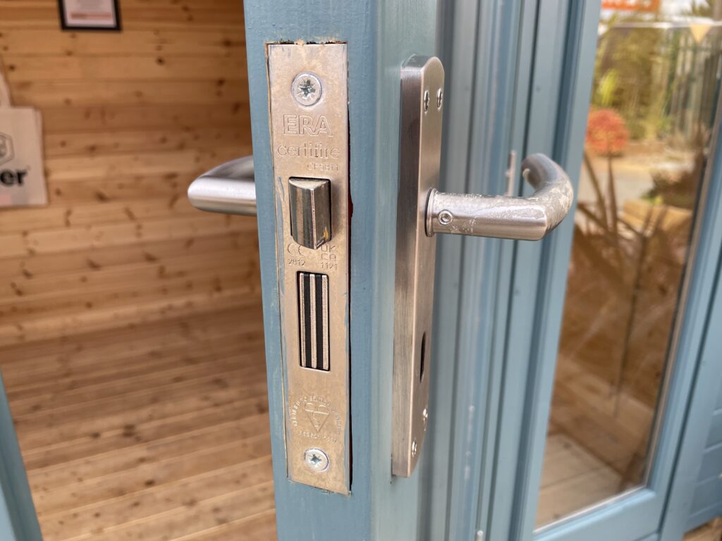 Close-up of ERA Certifire door lock and handle on Tiger Aura 44 mm Log Cabin at Tong show site.