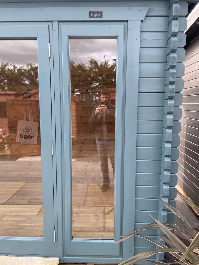 Close-up of full-height glazed door panel on Tiger Aura 44 mm Log Cabin at Tong show site.