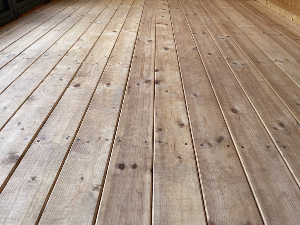 Detailed close-up of tongue and groove floorboards in Tiger Aura 44 mm Log Cabin at Tong show site.
