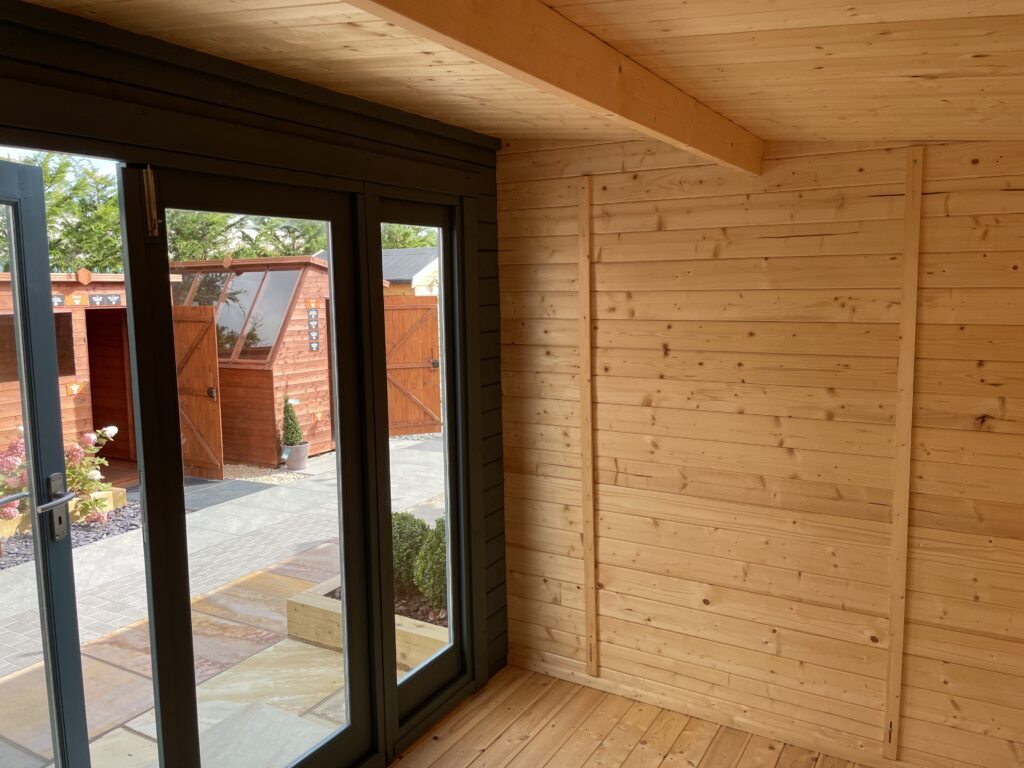 Interior view of Tiger Aura 44 mm Log Cabin at Tong show site looking through full-height glazed doors onto display area outside.