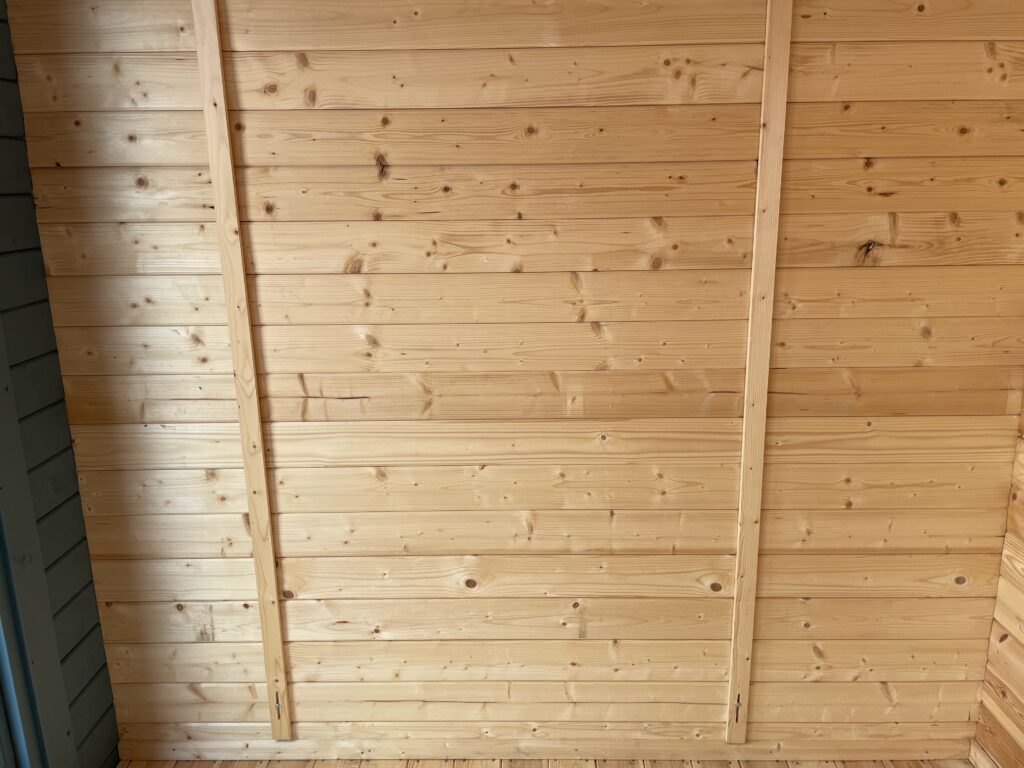 Interior wall view of Tiger Aura 44 mm Log Cabin at Tong show site showing tongue-and-groove timber panels and smooth finish.