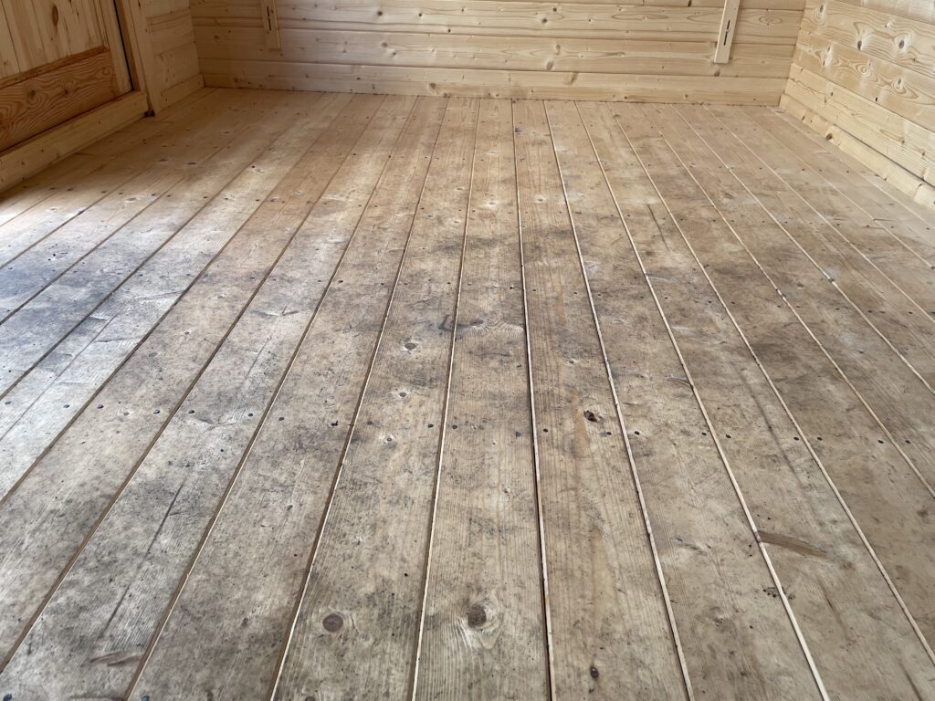 Interior close-up of the Tiger Persian 28 mm Log Cabin floorboards at the Otley show site showing the solid timber construction and natural grain detail.