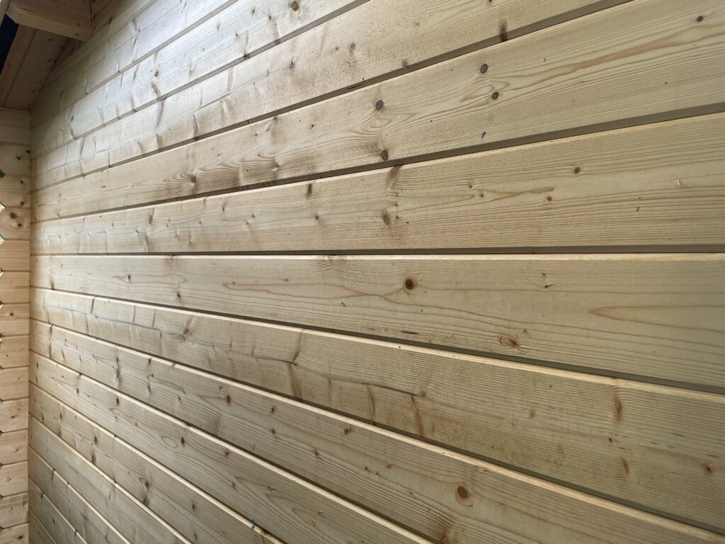 Side wall profile of the Tiger Persian 28 mm Log Cabin at the Otley show site showing smooth machined tongue-and-groove wall timbers.