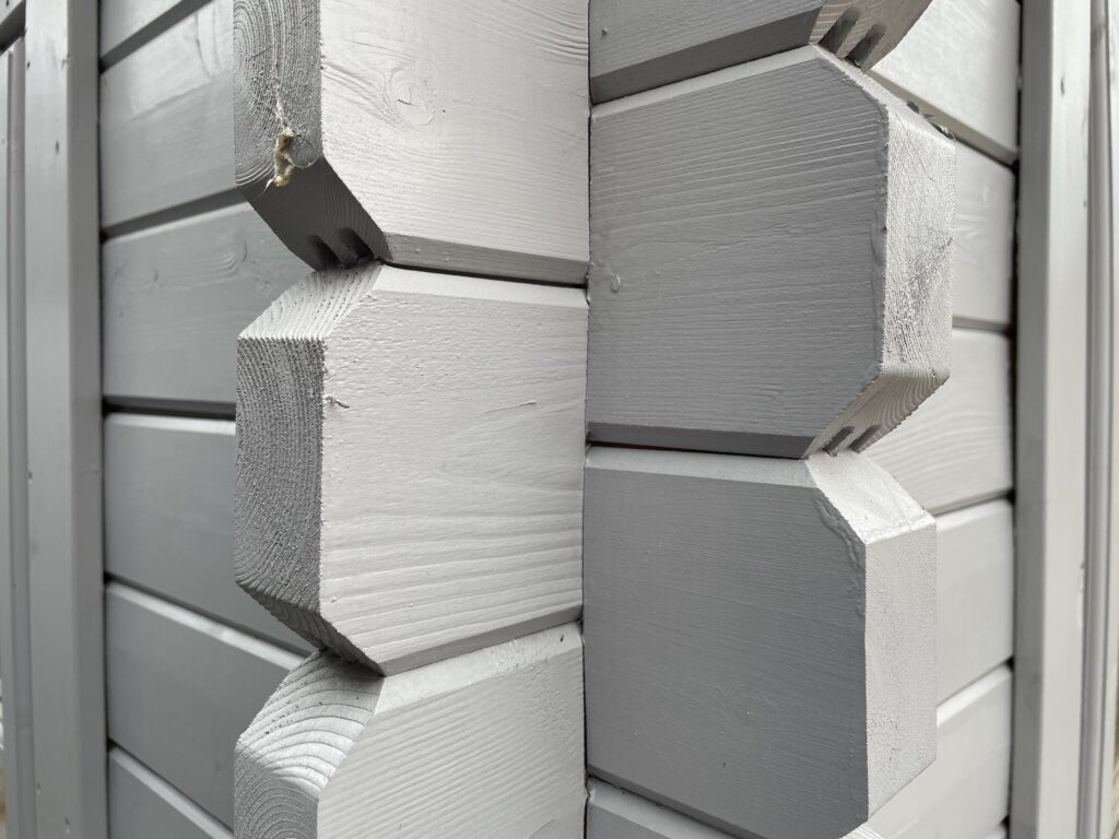 Close-up of Tiger Rho 44 mm Log Cabin corner joint at Horsforth show site showing interlocking log detail and painted finish.