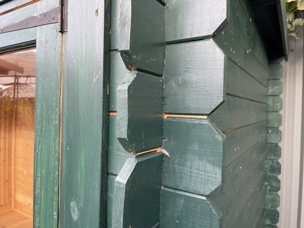 Close-up of green timber corner joint on a garden building