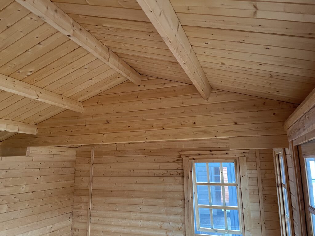 Interior view of a log cabin featuring an apex roof and Georgian-style windows