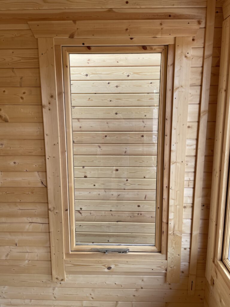 Full-pane window with wooden cladding in a garden building