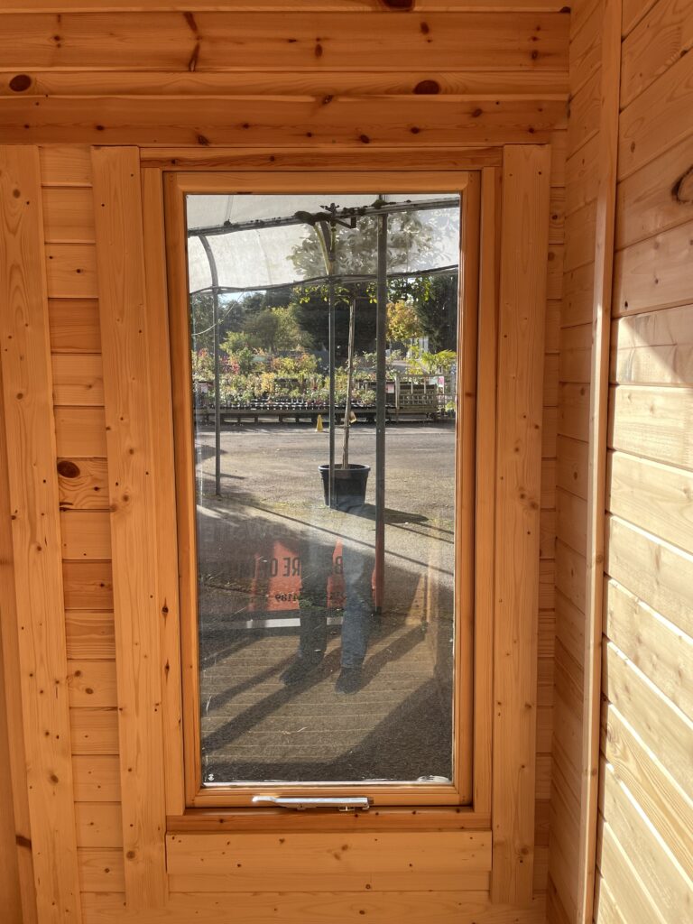 Full-pane window showcasing natural light in a wooden garden building