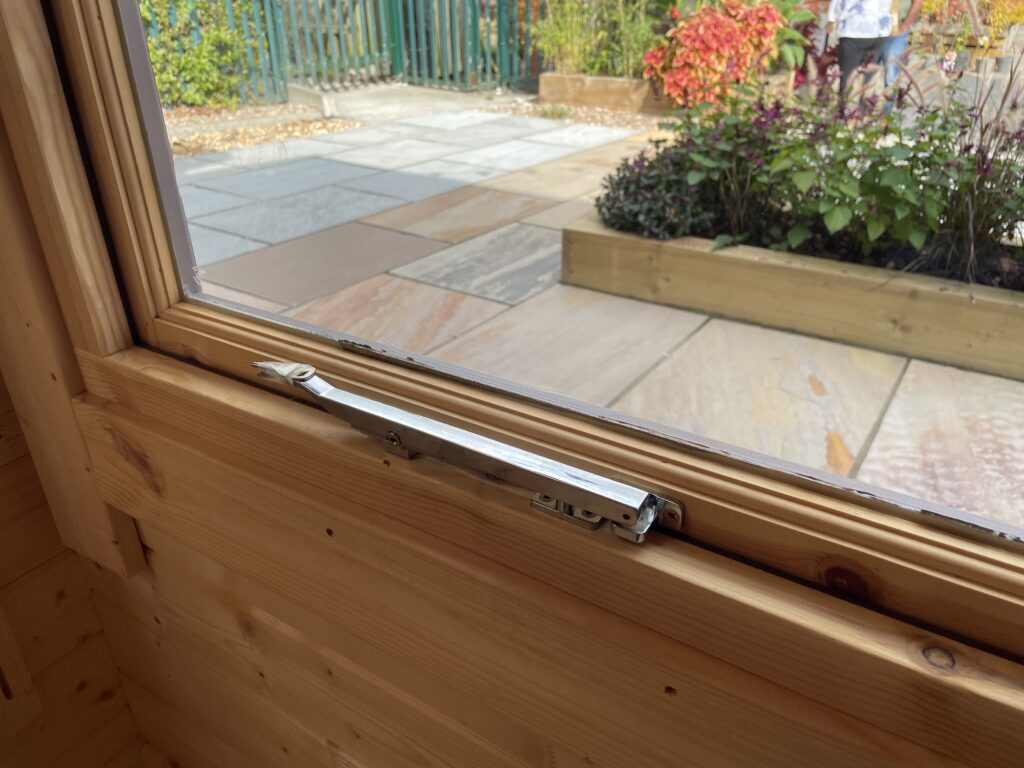 Full-pane window hardware in a wooden garden building