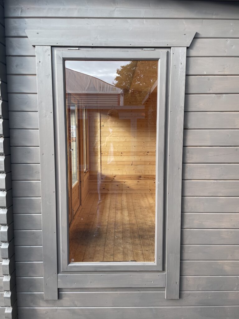 Full-pane window with wooden cladding in a garden building