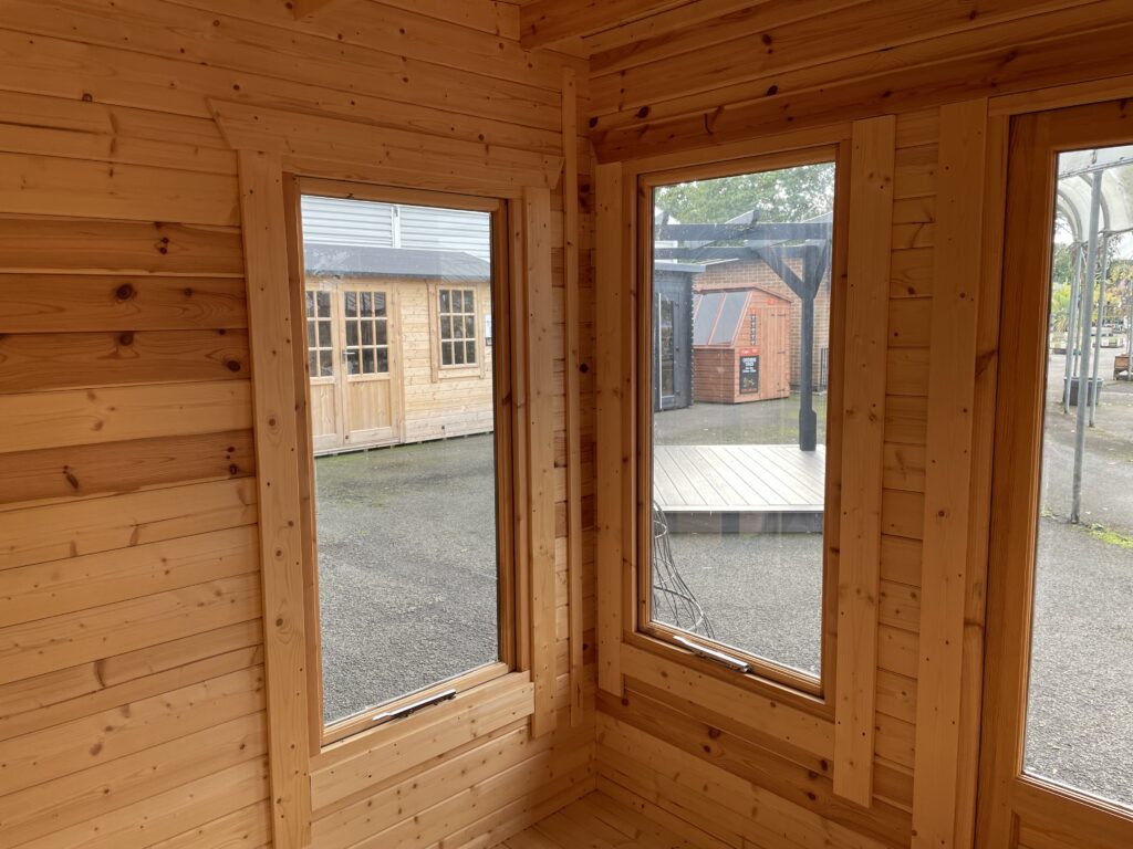 Interior view showcasing three large windows in a log cabin