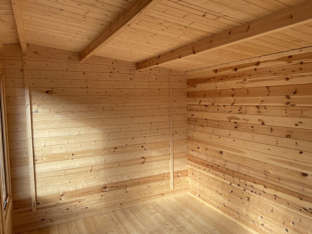 Interior view showcasing timber walls and ceiling of a garden building