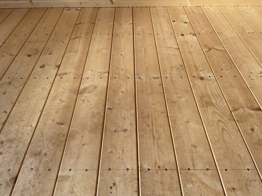 Timber floor featuring well-aligned planks and visible nails