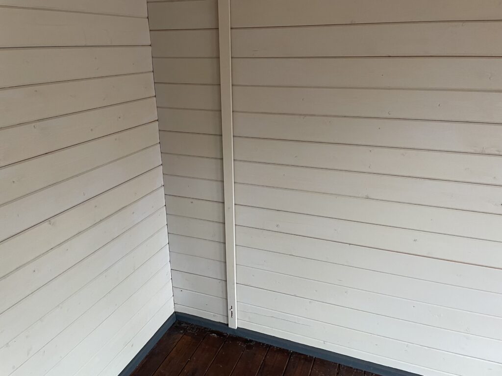 Interior view of a white garden building with smooth wooden walls