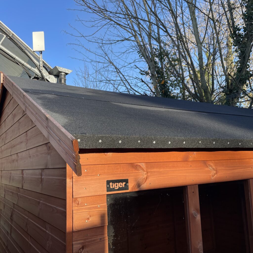 Apex roof of a timber garden building with felt covering