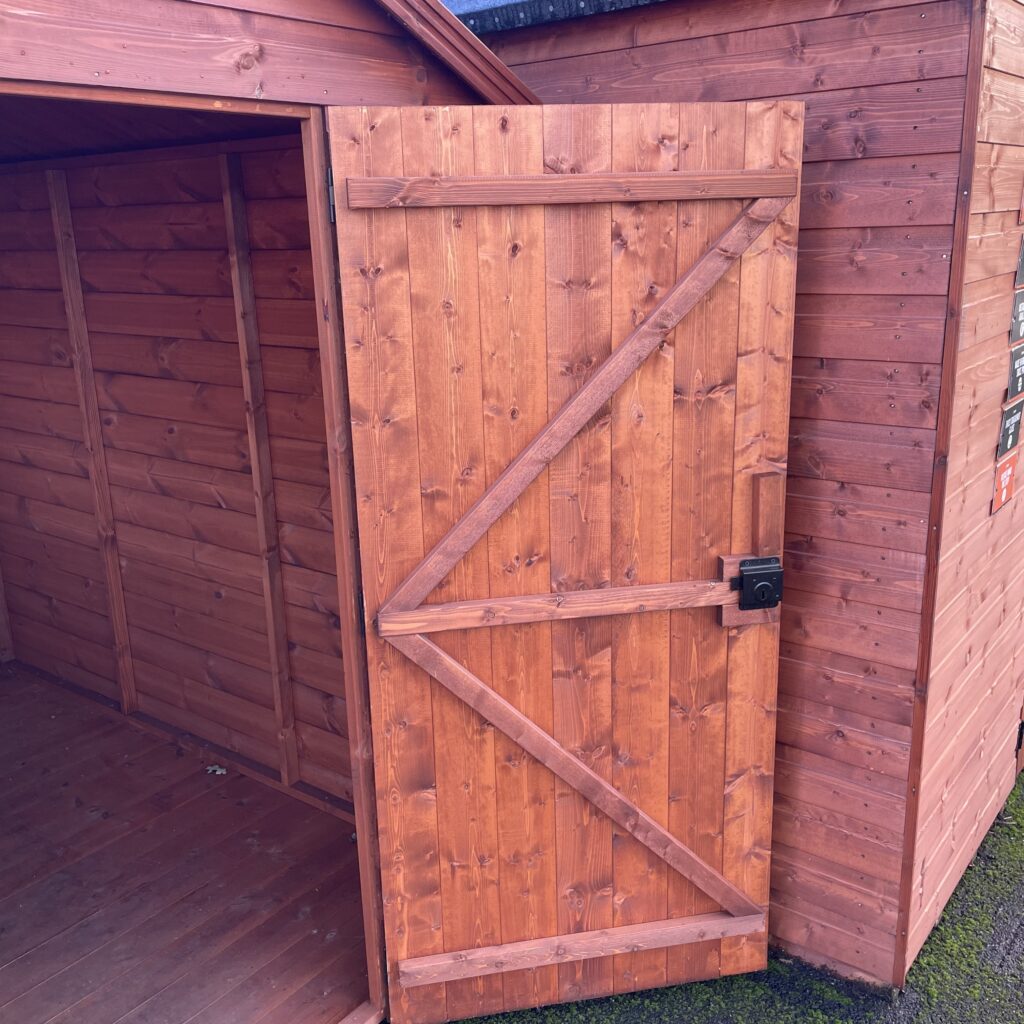 Brown wooden door with diagonal bracing and lock