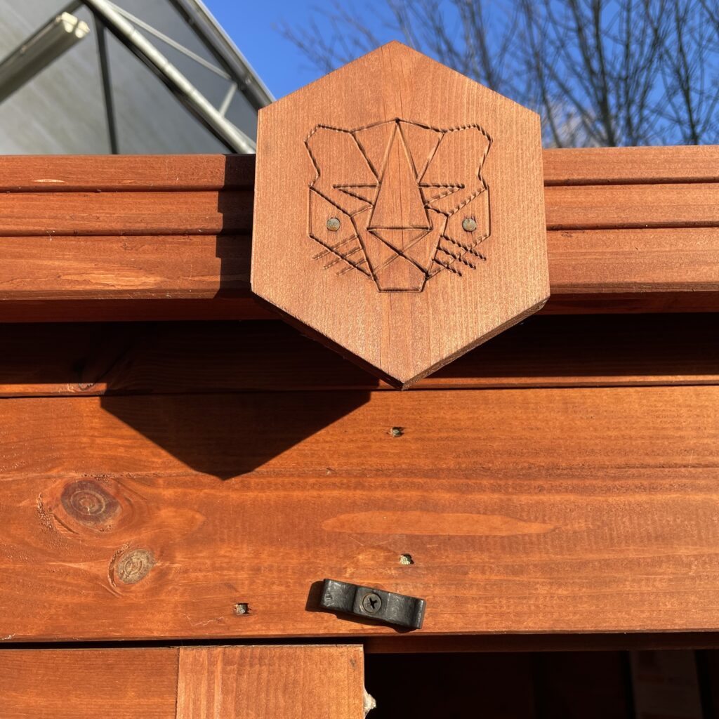 Close-up of Tiger logo on a wooden garden building