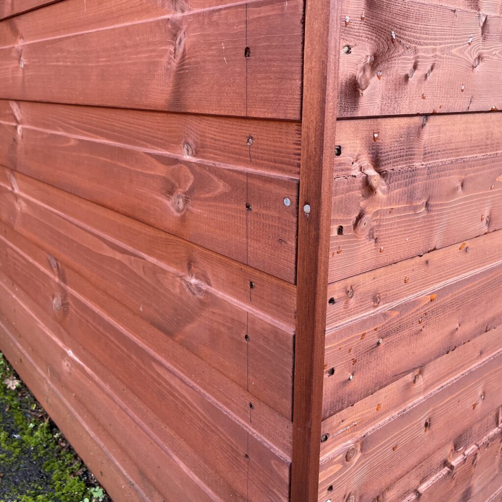 Detailed view of overlapping timber cladding on a garden building