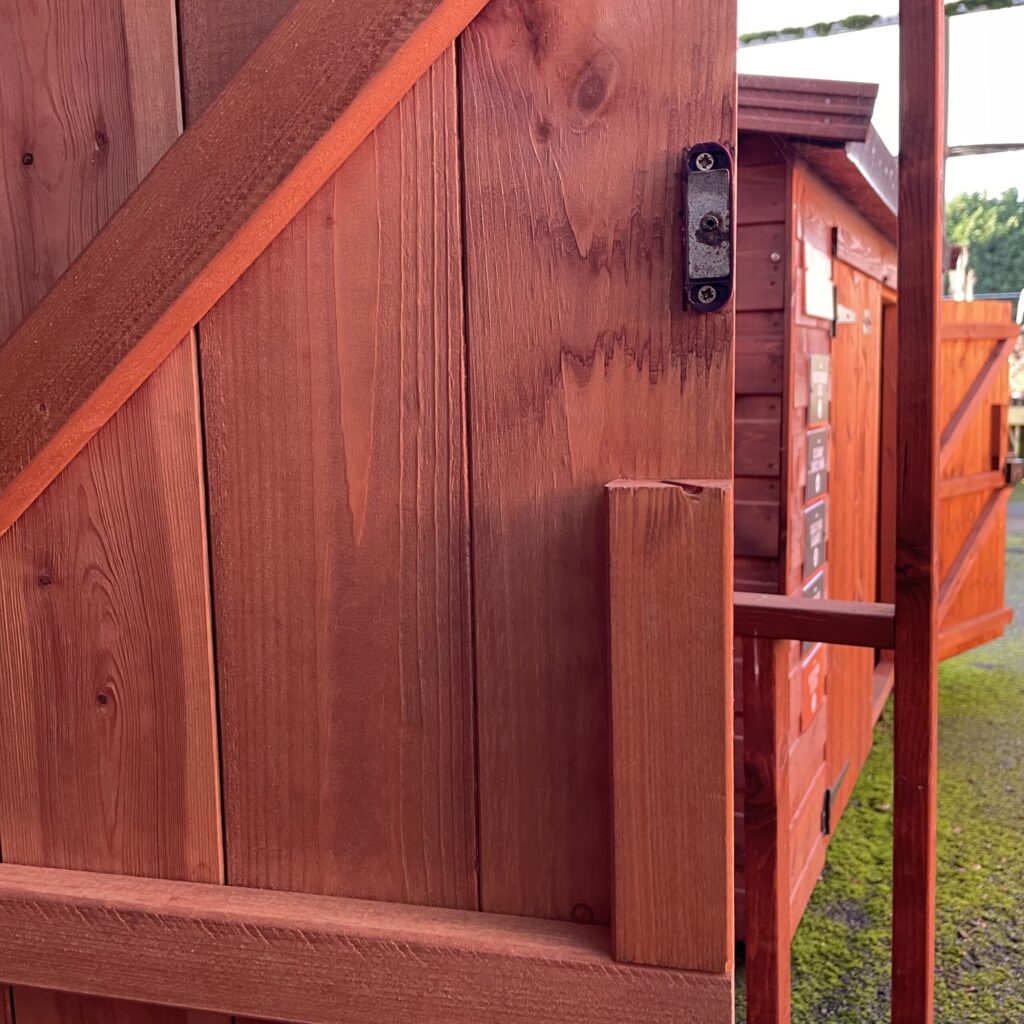 Close-up of a wooden door featuring diagonal bracing and a latch mechanism