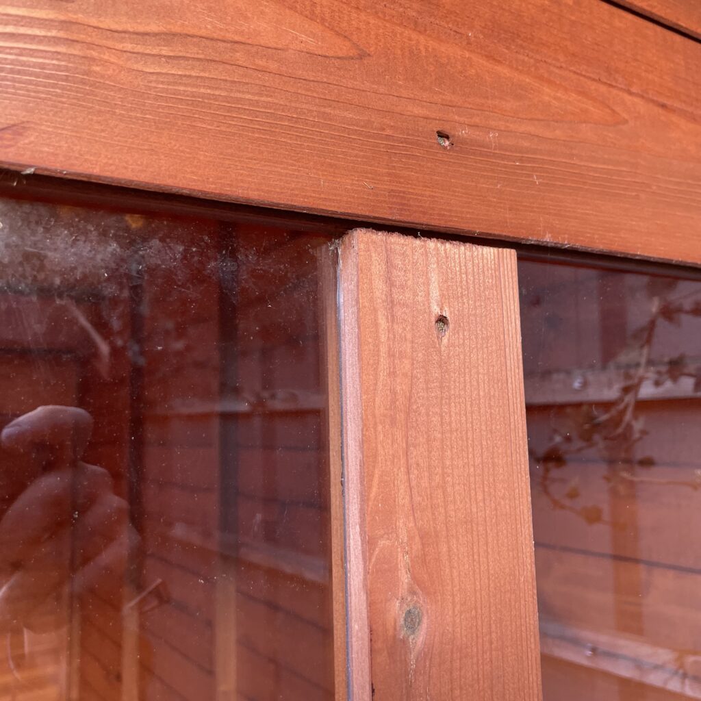 Wooden frame detail with glass panel in a garden building
