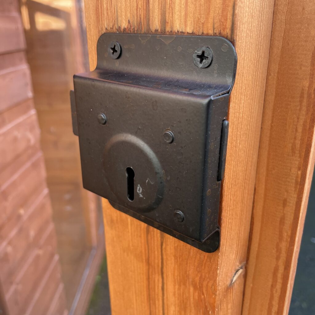 Close-up of a lock mechanism on a wooden garden building