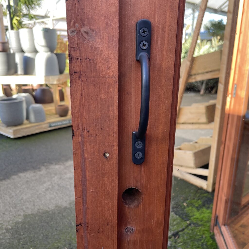 Close-up of the door handle on a wooden summerhouse