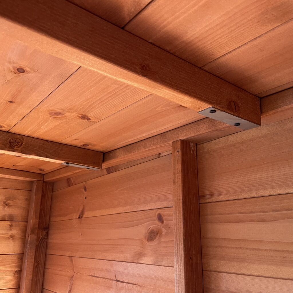 Corner joint detail of the Tiger Corner Summerhouse showcasing wooden beams and metal support