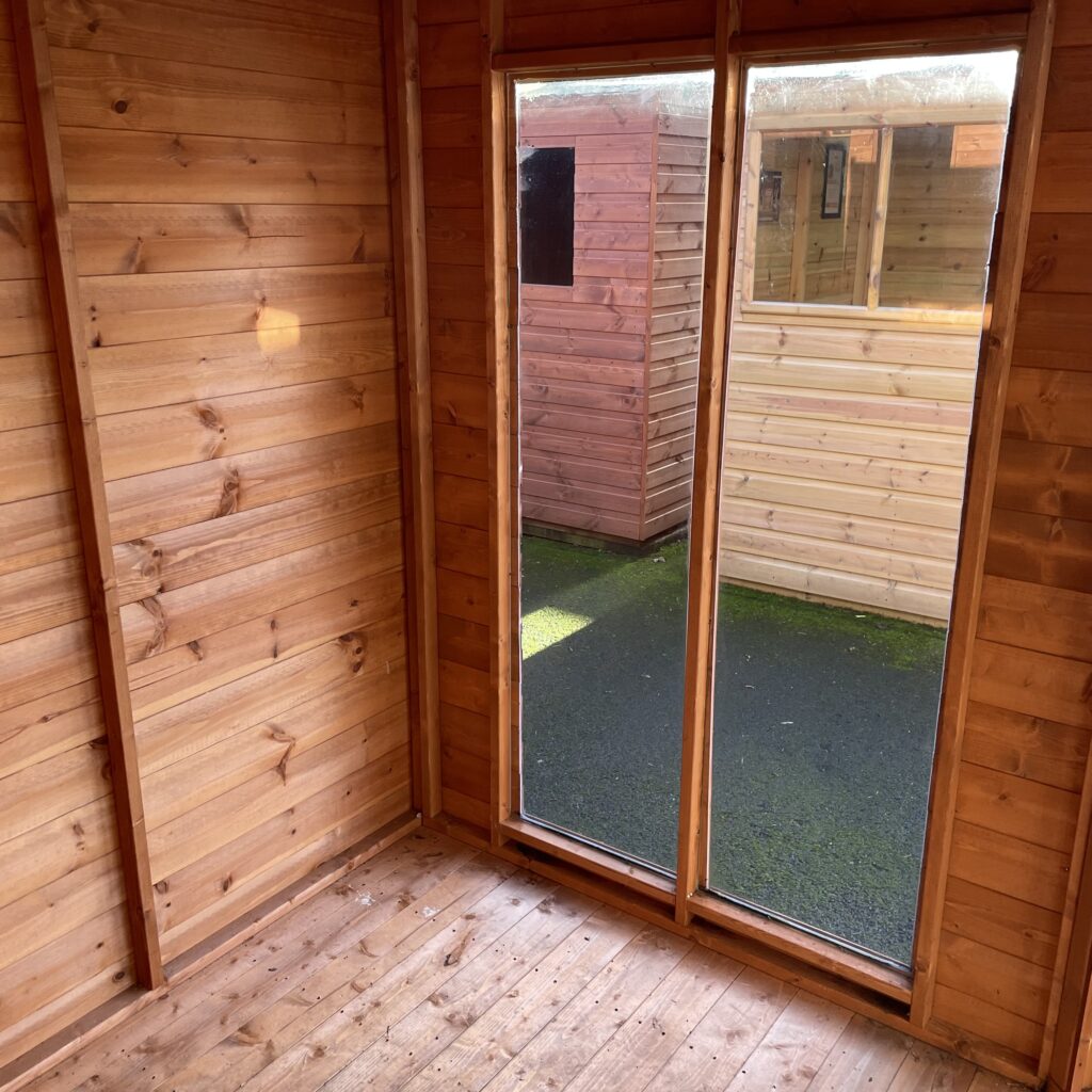 Interior of the Tiger Corner Summerhouse with large double doors and wooden walls