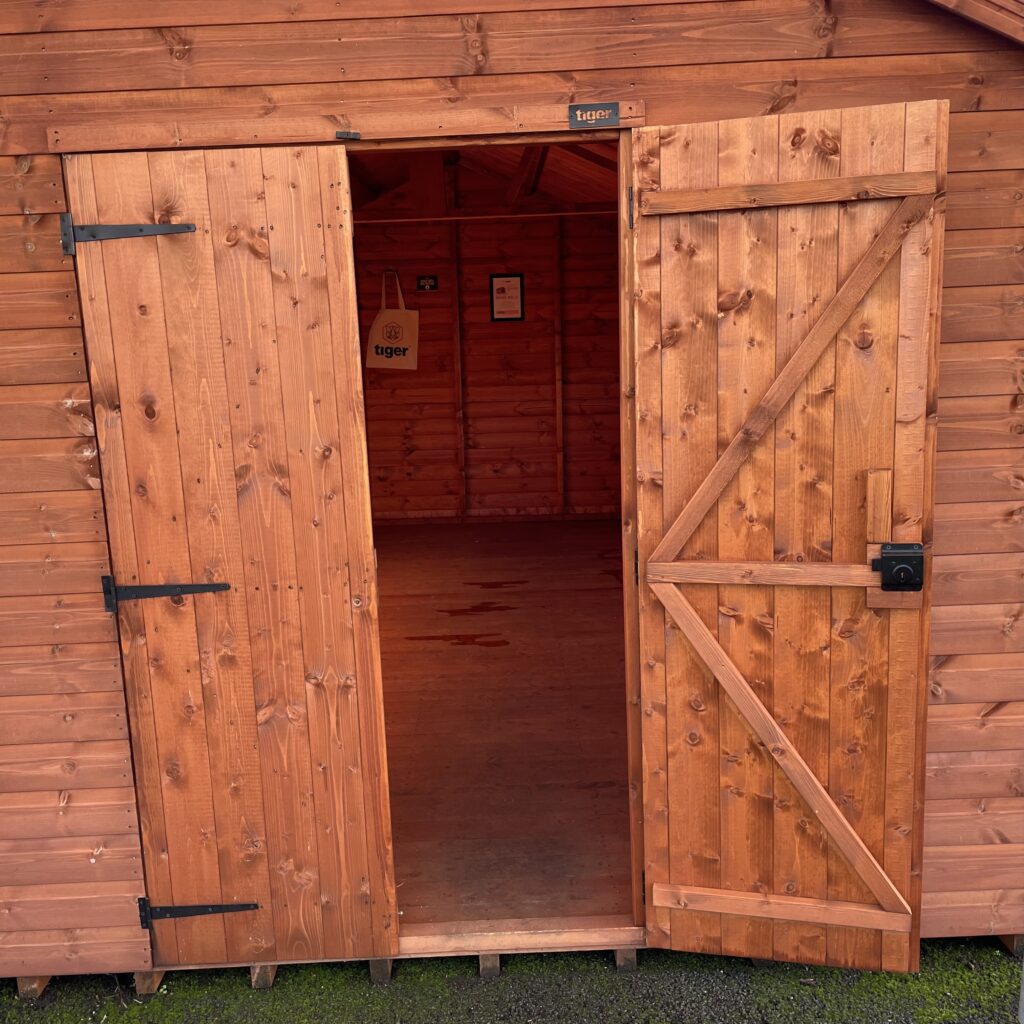 Double doors of a wooden garden building opening to the interior
