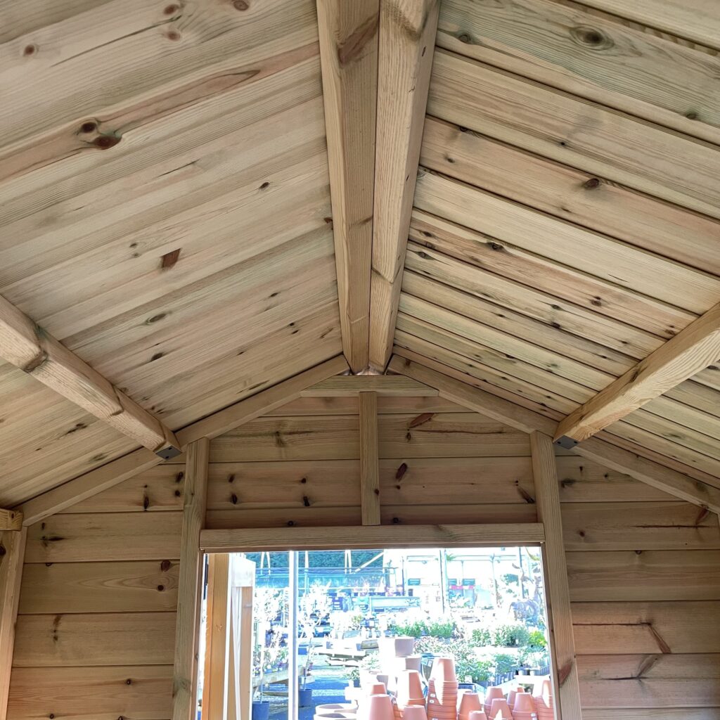 Interior view of an apex shed roof showcasing wooden beams and planks