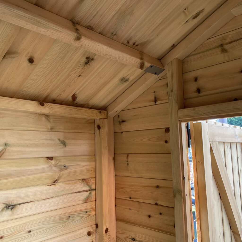 Interior view of an apex shed highlighting wooden cladding and structural beams