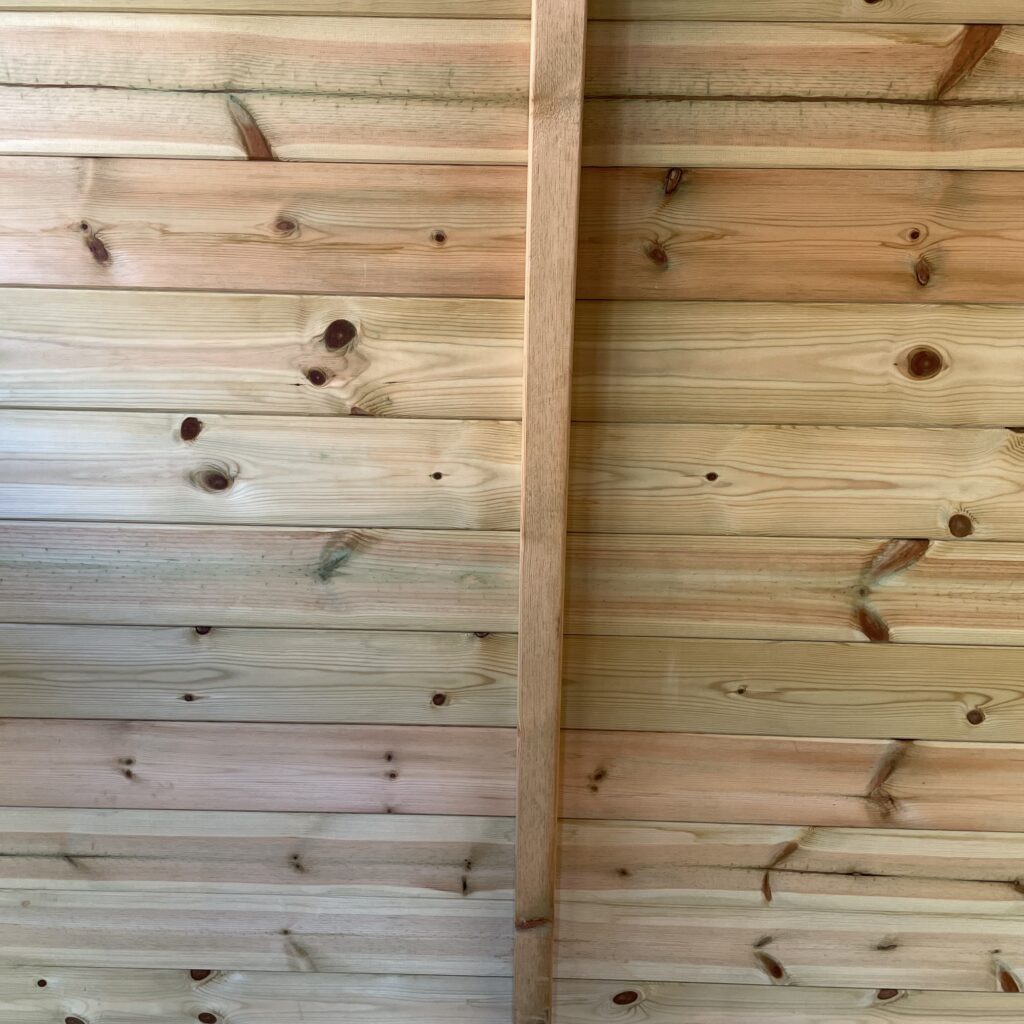 Interior view of wooden wall cladding in an apex shed
