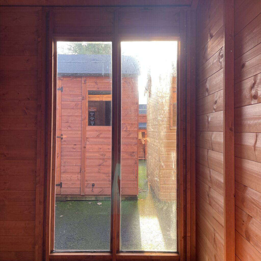 Interior view of a garden building with wooden walls and double doors