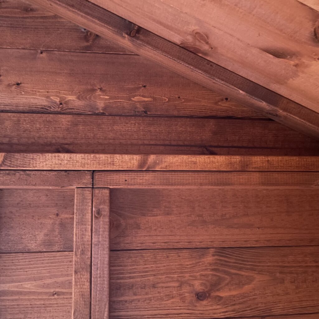 Interior view of a log cabin with wooden cladding and beams