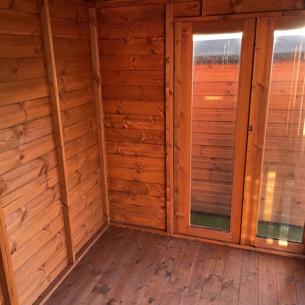 Interior view of a wooden garden building featuring double doors