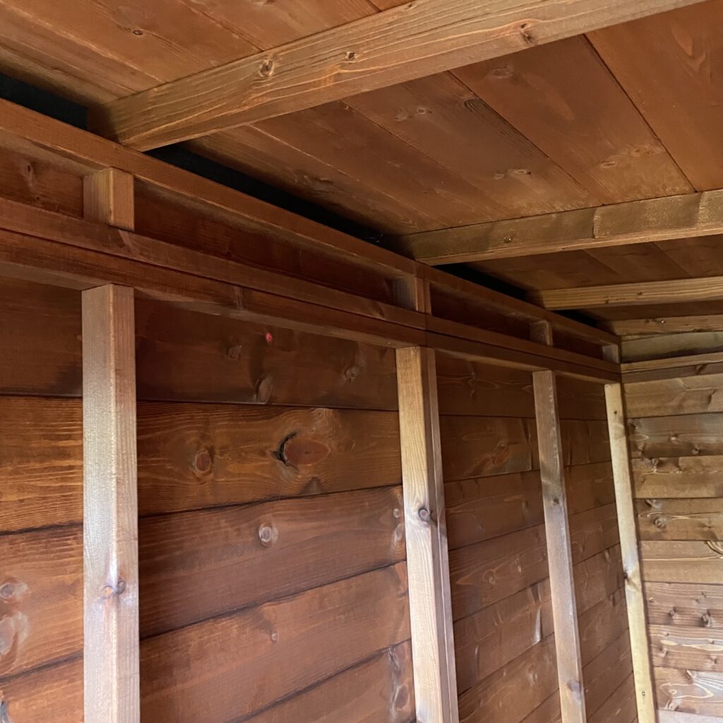 Interior view of a wooden garden building with cladding and framework