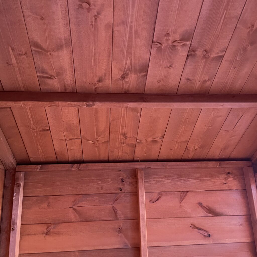 Interior view of a wooden garden building with a smooth ceiling