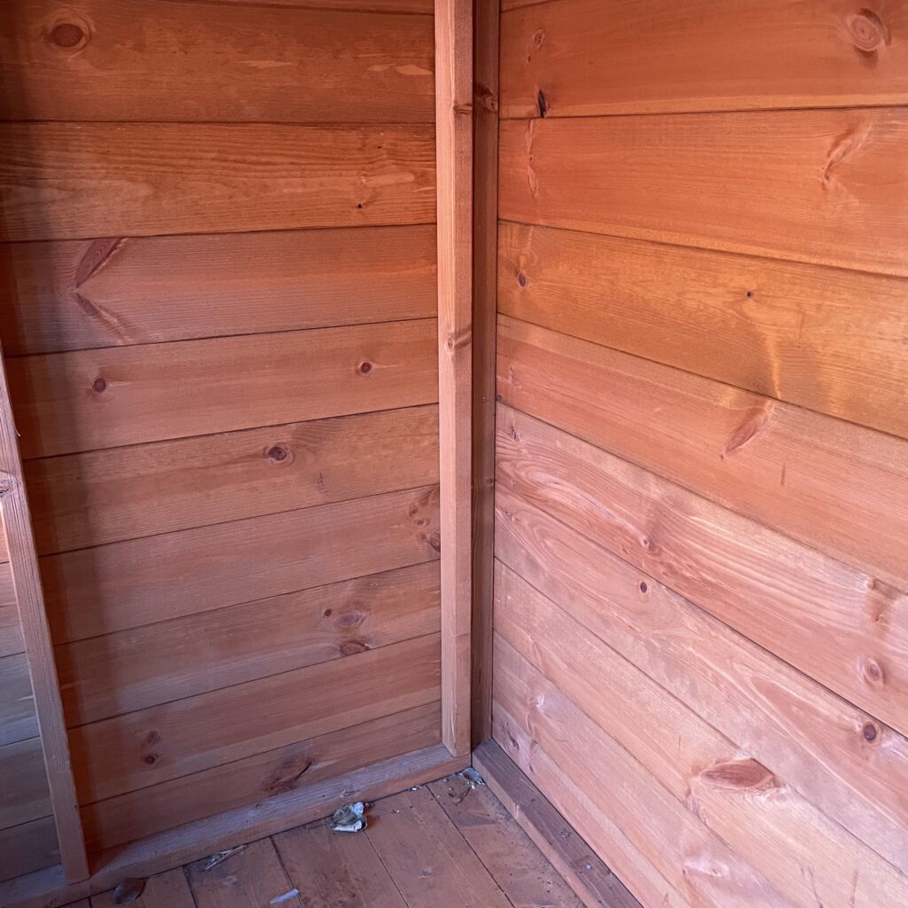 Interior of a Tiger playhouse showing tongue-and-groove cladding and floorboards