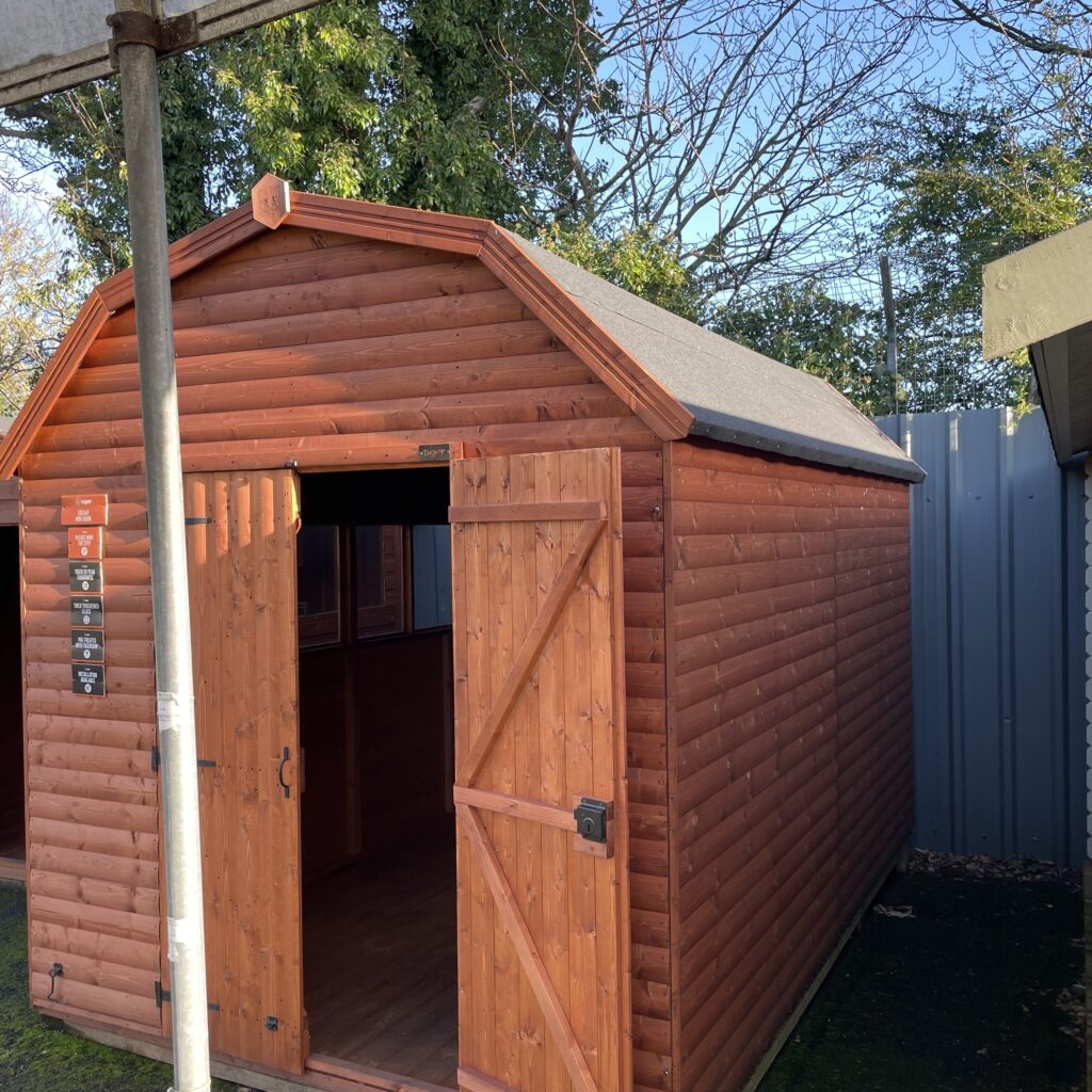 Front view of a brown timber garden building with an open door