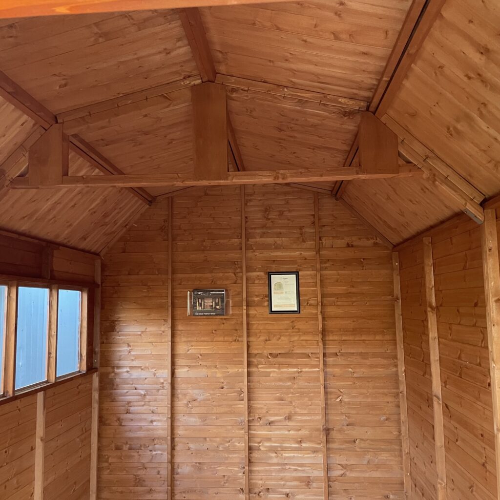 Interior of a Tiger Loglap Mini-Barn showcasing wooden walls and windows