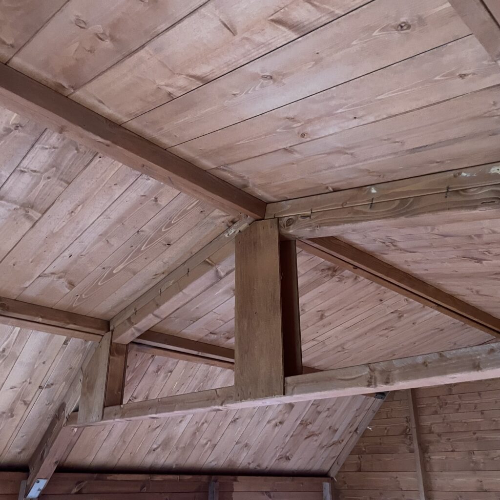Interior view showcasing the ceiling and wooden beams of a garden building