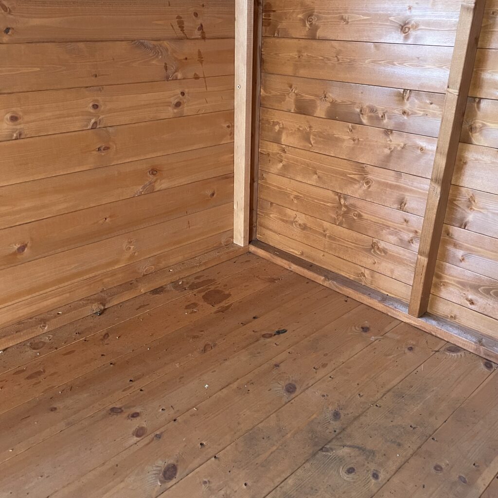 Interior view of the Tiger Loglap Mini-Barn with wooden walls and floor