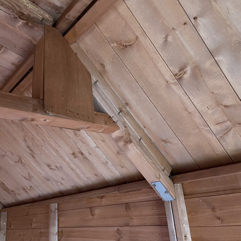 Interior view of the Tiger Loglap Mini-Barn showing wooden beams and panels