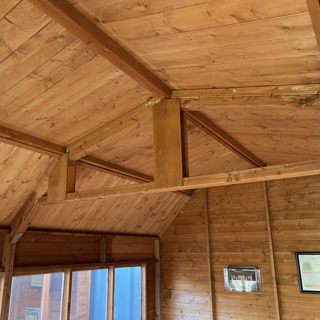 Interior view of the Tiger Loglap Mini-Barn showing wooden beams and cladding