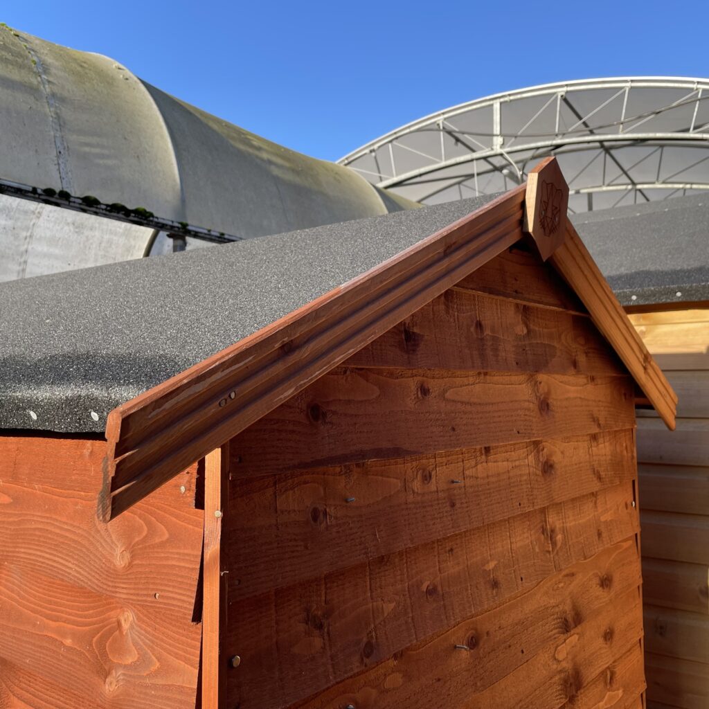 Detail of the apex roof and wooden cladding of a garden shed