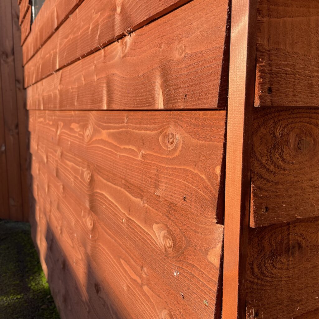 Close-up of the shed's overlapping wooden cladding