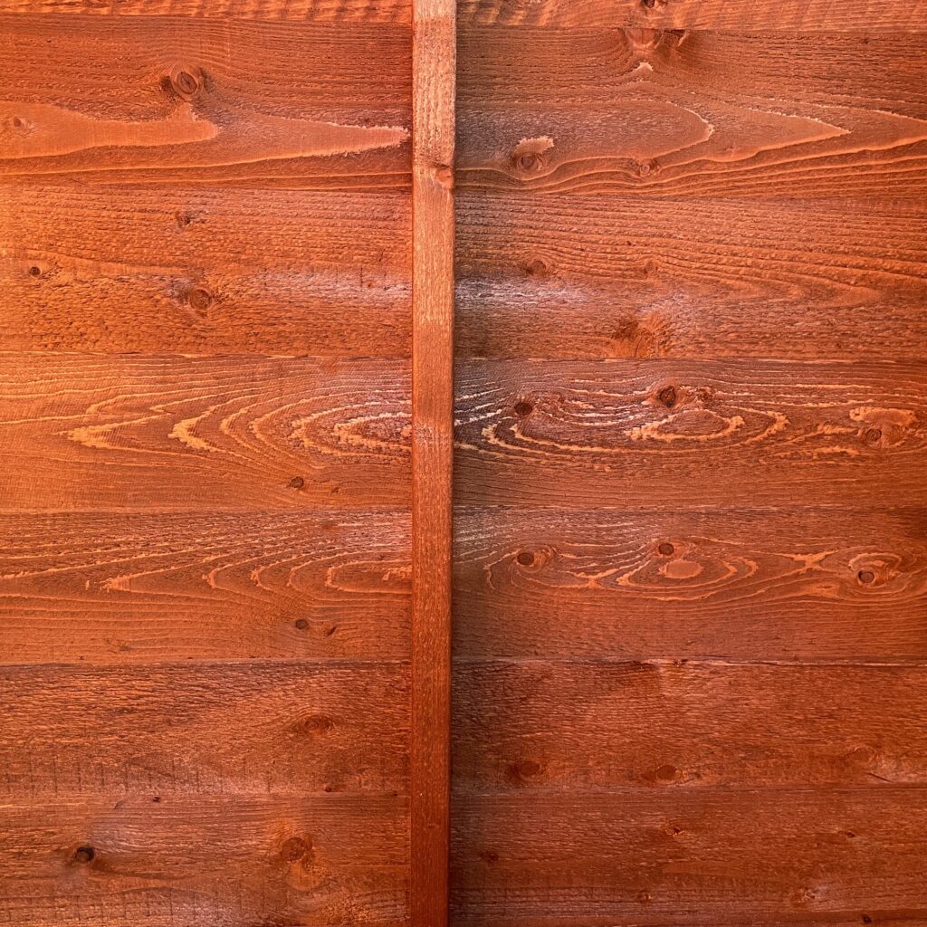 Interior wall of a wooden shed with visible grain patterns