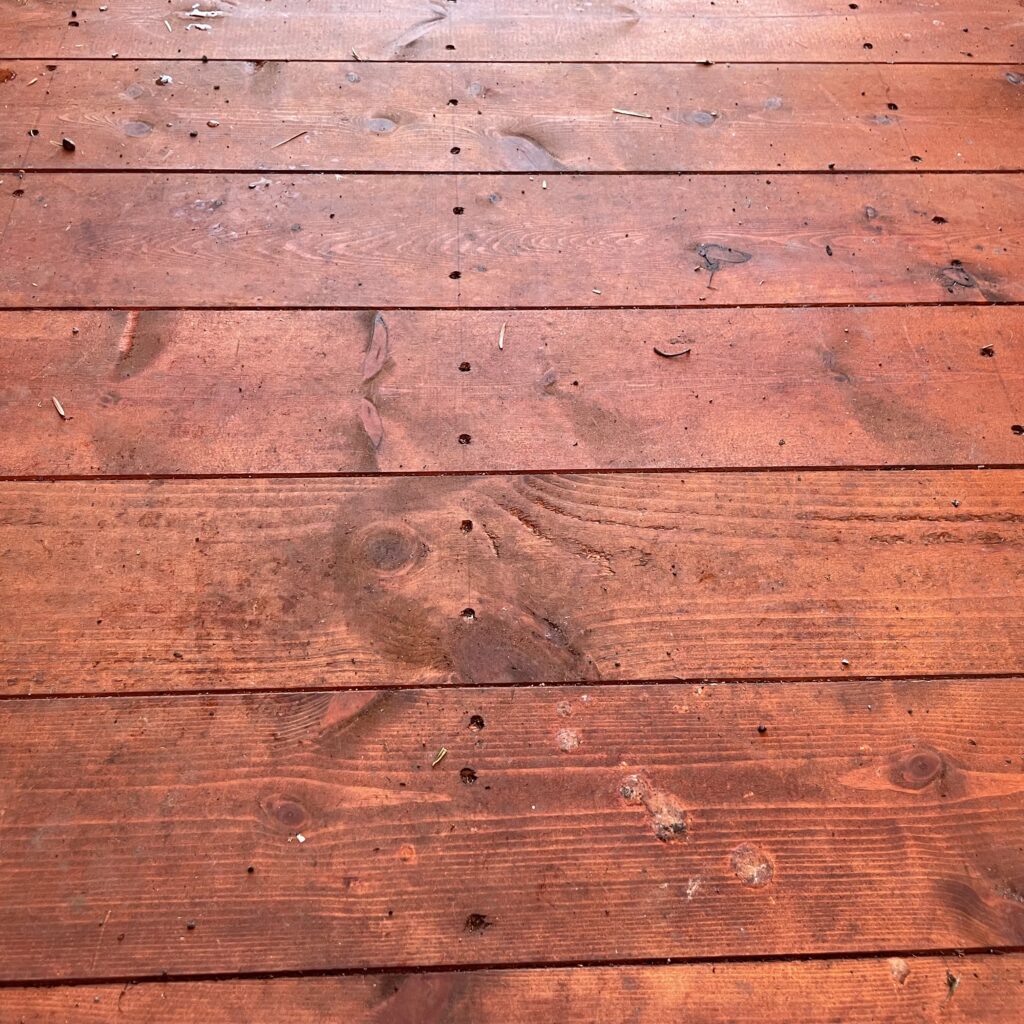 Close-up of the wooden floor of a Tiger Overlap Apex Shed showing grain and debris