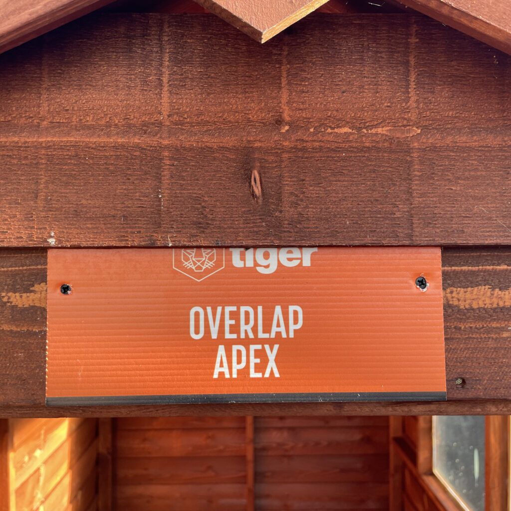 Signage displaying 'Tiger Overlap Apex Shed' at a show site